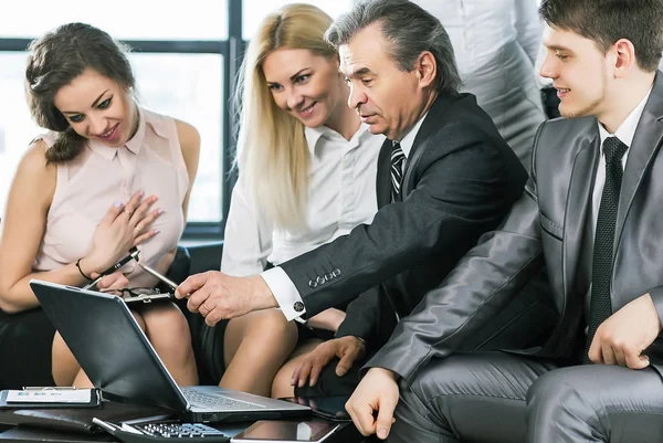 Grupo de empresarios que discuten las políticas de la empresa utilizando el ordenador portátil — Foto de Stock