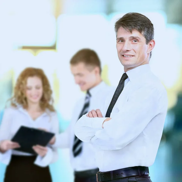 Uomo d'affari di successo in piedi con il suo personale in background — Foto Stock