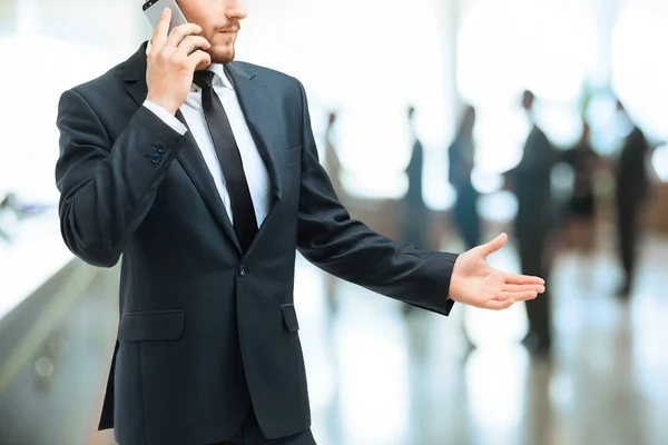 Серьезный бизнесмен разговаривает на смартфоне в офисе — стоковое фото