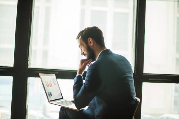 Manager with a laptop, working  financial charts near  larg — Stock Photo, Image