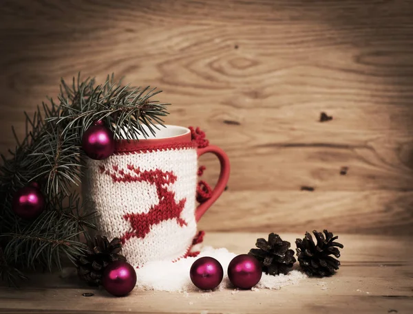 Tazza di Natale con decorazione a maglia di cervo sullo sfondo di legno — Foto Stock