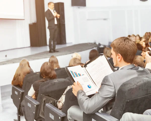 Relatore ad un convegno di lavoro e presentazioni. Il pubblico seduto uomo d'affari analizza fatto dal rapporto — Foto Stock