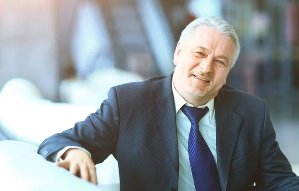 Businessman in office sitting on couch smiling and looking at the frame — Stock Photo, Image