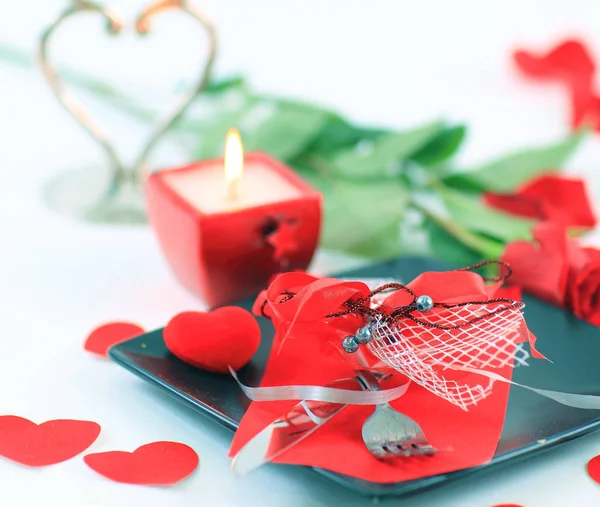 Sztućce na ciemne płytki ze świecą urządzone na Walentynki — Zdjęcie stockowe