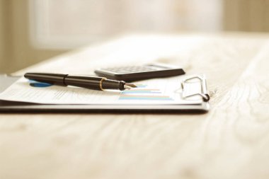 kalem, hesap makinesi ve mali grafik üzerinde bir çalışma alanı