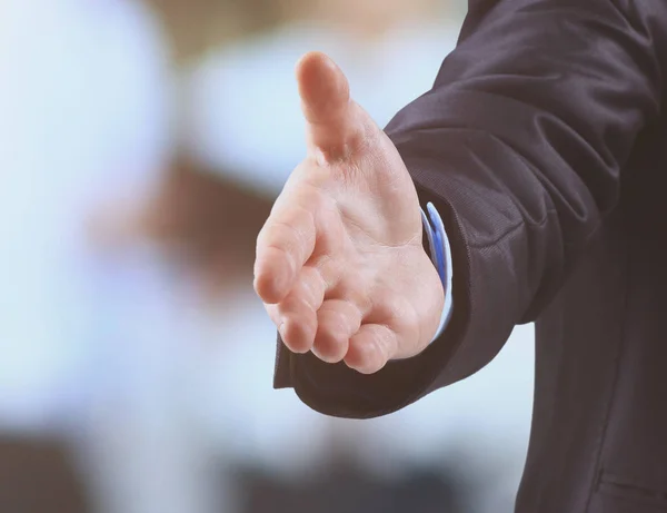 Homem de negócios com uma mão aberta pronto para fechar um negócio no fundo do trabalho em equipe — Fotografia de Stock