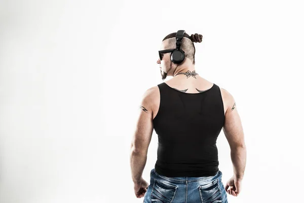 Visão traseira - DJ - rapper com um penteado elegante com fones de ouvido — Fotografia de Stock