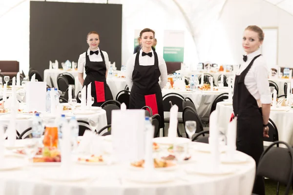 Grupo de camareros en un prestigioso restaurante sirve mesas a la th — Foto de Stock
