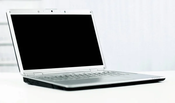 Portátil de plata en oficina moderna con pantalla oscura para texto o publicidad —  Fotos de Stock