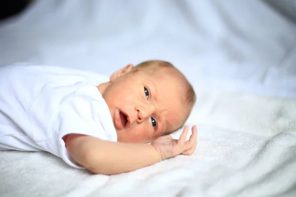 Mignon nouveau-né couché sur une couverture blanche — Photo