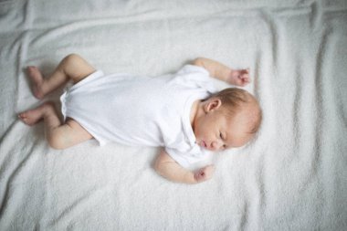 Yatakta uyuyan sevimli bebek