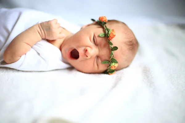 Serene newborn baby on a bed yawning — Stock Photo, Image