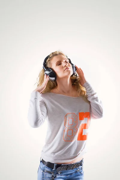 Happy cute young woman with headphones listening to music — Stock Photo, Image