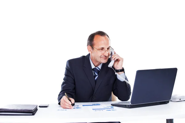 Självsäker affärsman på arbetsplatsen i kontoret av en laptop som pratar i telefon — Stockfoto