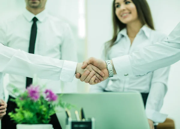 Händedruck von Geschäftspartnern über Hintergrund von Büroangestellten — Stockfoto