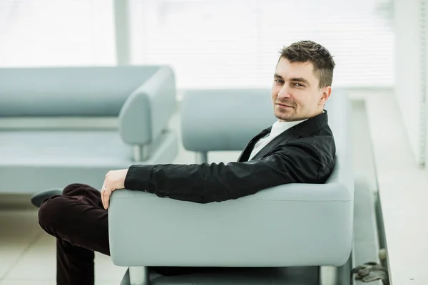 Επιτυχημένος επιχειρηματίας που κάθεται σε μια καρέκλα στο λόμπι του σύγχρονου γραφείου .the φωτογραφία έχει ένα κενό διάστημα για το κείμενό σας — Φωτογραφία Αρχείου