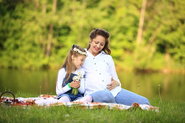 Concept of maternity - pregnant mother and little daughter havin — Stock Photo, Image
