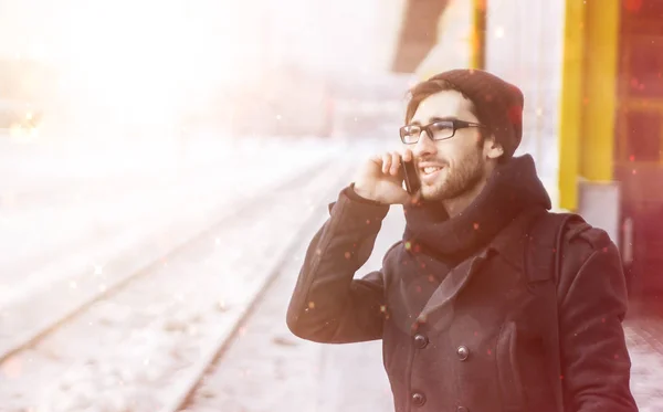 Giovane uomo elegante con uno smartphone in piedi in una stazione della metropolitana — Foto Stock