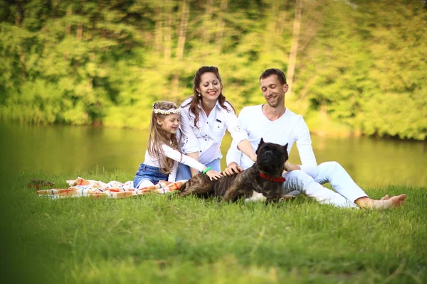 Glückliche Familie mit Hund beim Picknick an einem sonnigen Sommertag. pregn — Stockfoto