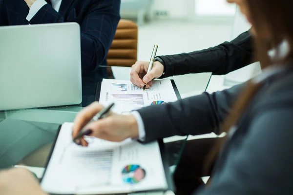 Equipo de negocios discutiendo cartas financieras en un lugar de trabajo — Foto de Stock