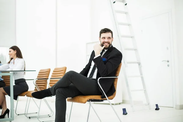 Şirketin başarılı çalışan işyeri ofis yakın bir sandalyede oturur. — Stok fotoğraf
