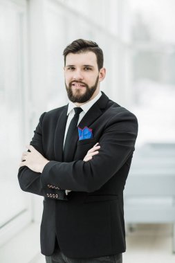 parlak ofiste bir pencere yakınında duran başarılı iş adamı.