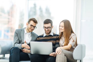 çalışanların ofis lobisinde oturan bir dizüstü bilgisayar ile