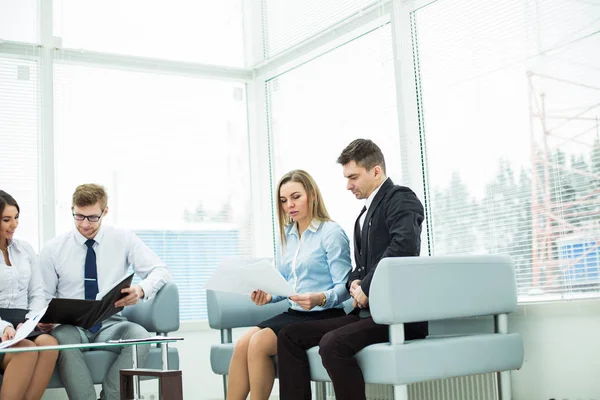 Dipendenti dell'azienda con documenti seduti nella sala di ricevimento prima della conferenza — Foto Stock