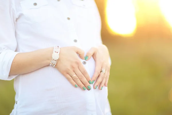 Donna incinta in una passeggiata nel parco in una giornata di sole — Foto Stock