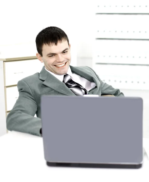 Hombre de negocios exitoso en una oficina moderna que trabaja detrás de una computadora portátil —  Fotos de Stock