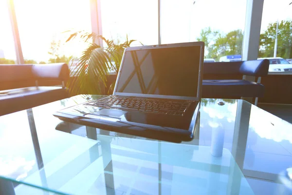 Desktop of a modern desktop with a laptop in the office on a glass table — Stock Photo, Image