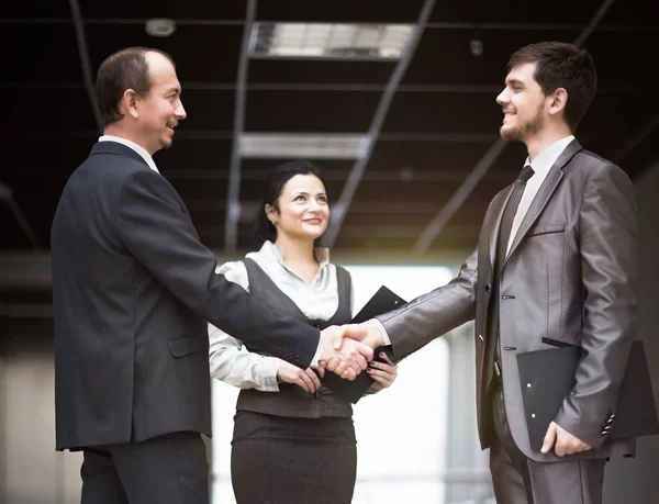 握手で取引を修正最新の業績を議論する事業チームのイメージ — ストック写真