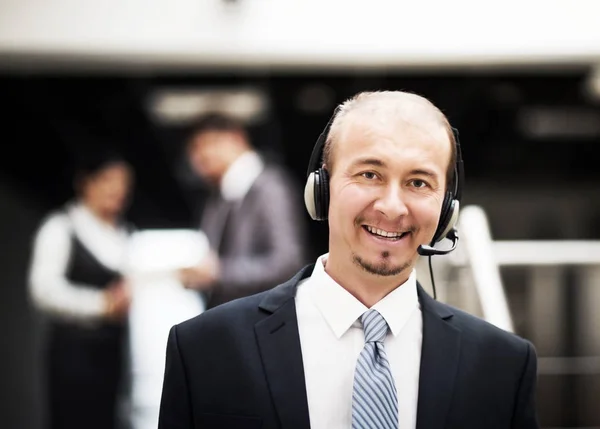 Joven operador de servicio al cliente hablando en los auriculares, sonriendo . — Foto de Stock