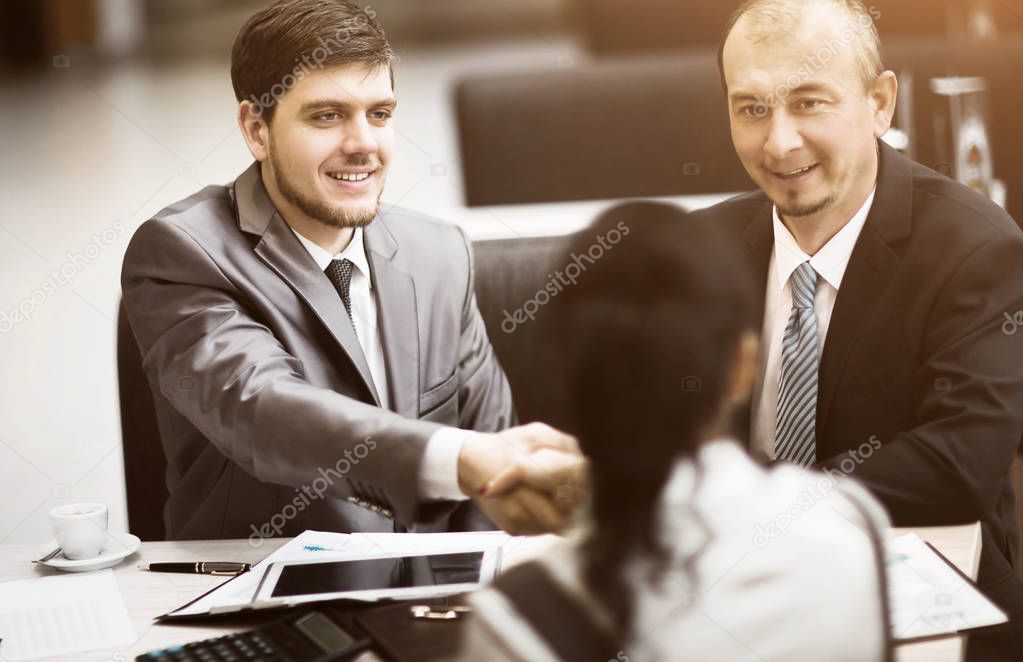 Business people shaking hands, finishing up a meeting, in the office