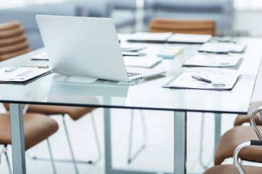 laptop ve üstünde okul sırası şirketin muhasebe bölümündeki belgeleri