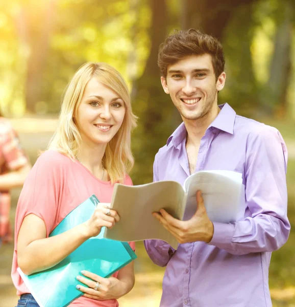 Gäng glada studenter med böcker parken en solig dag. — Stockfoto