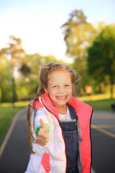 Potret gadis kecil yang bahagia membuat jempol gerakan berjalan-jalan — Stok Foto