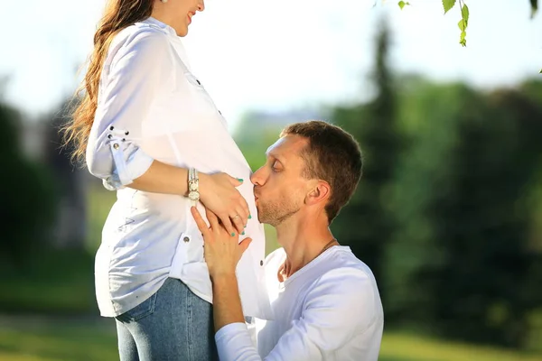 Glücklicher Ehemann umarmt seine schwangere Frau bei einem Spaziergang im Park — Stockfoto