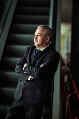 karanlık bir arka plan üzerinde modern bir ofis merdivenlerde durup başarılı iş adamı