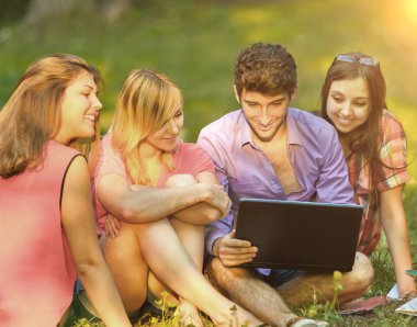 bir grup öğrenci ile laptop güneşli parkta rahatlatıcı