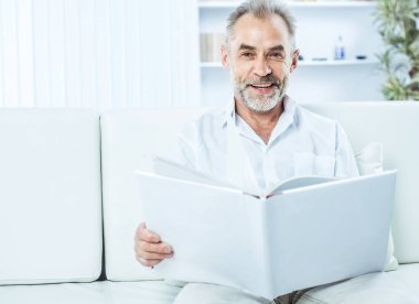 işadamı ile parlak Office kanepede oturan bir dergi.