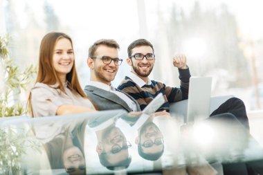 çalışanların ofis lobisinde oturan bir dizüstü bilgisayar ile