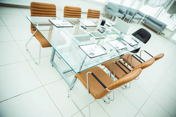 Mesa para negociações com os gráficos financeiros preparados e equipamentos de escritório na sala de conferências antes de reuniões de negócios . — Fotografia de Stock