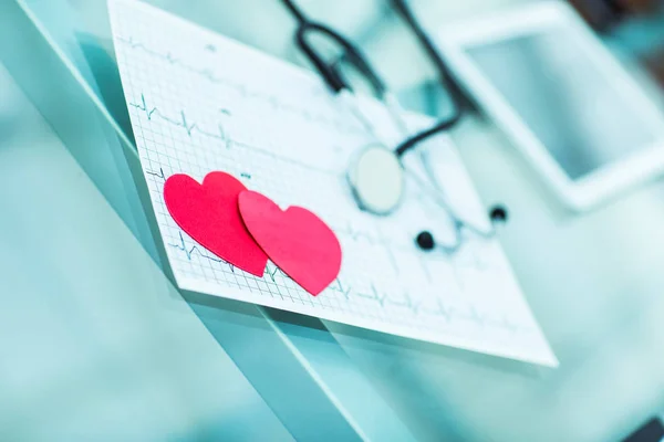 Gezondheid concept: twee rode papier hart op het elektrocardiogram, de cardioloog. — Stockfoto