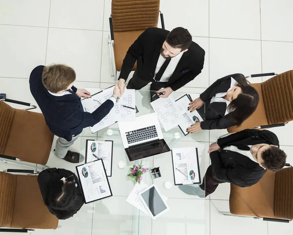 Apretón de manos de los socios comerciales antes de las conversaciones cerca del escritorio en — Foto de Stock