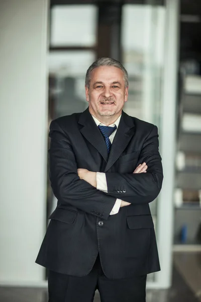 Retrato de un exitoso hombre de negocios en el fondo de la oficina moderna —  Fotos de Stock