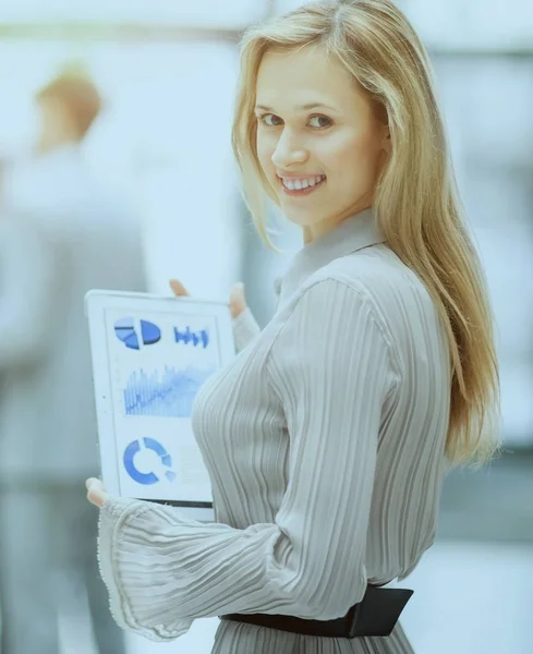 Успешная деловая женщина с финансовой картой на планшете на фоне бизнес-команды в офисе — стоковое фото