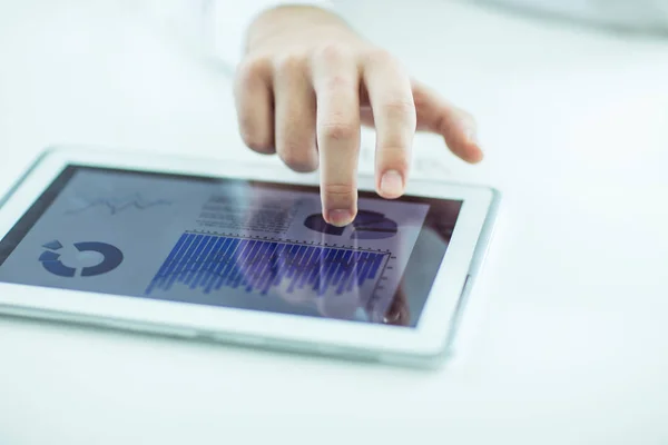 Бізнесмен використовує цифровий планшет, працюючи з фінансовим графіком на робочому столі — стокове фото