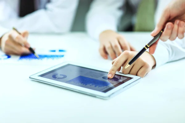 Бизнесмен с помощью цифрового планшета, работающий с финансовым расписанием на столе — стоковое фото