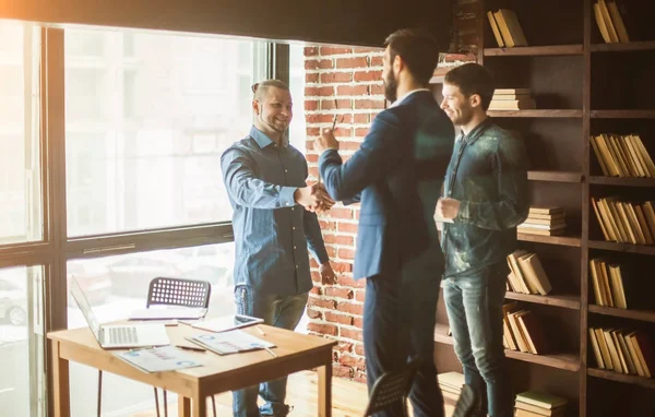 Gerente de la empresa da la bienvenida al cliente con un apretón de manos en — Foto de Stock